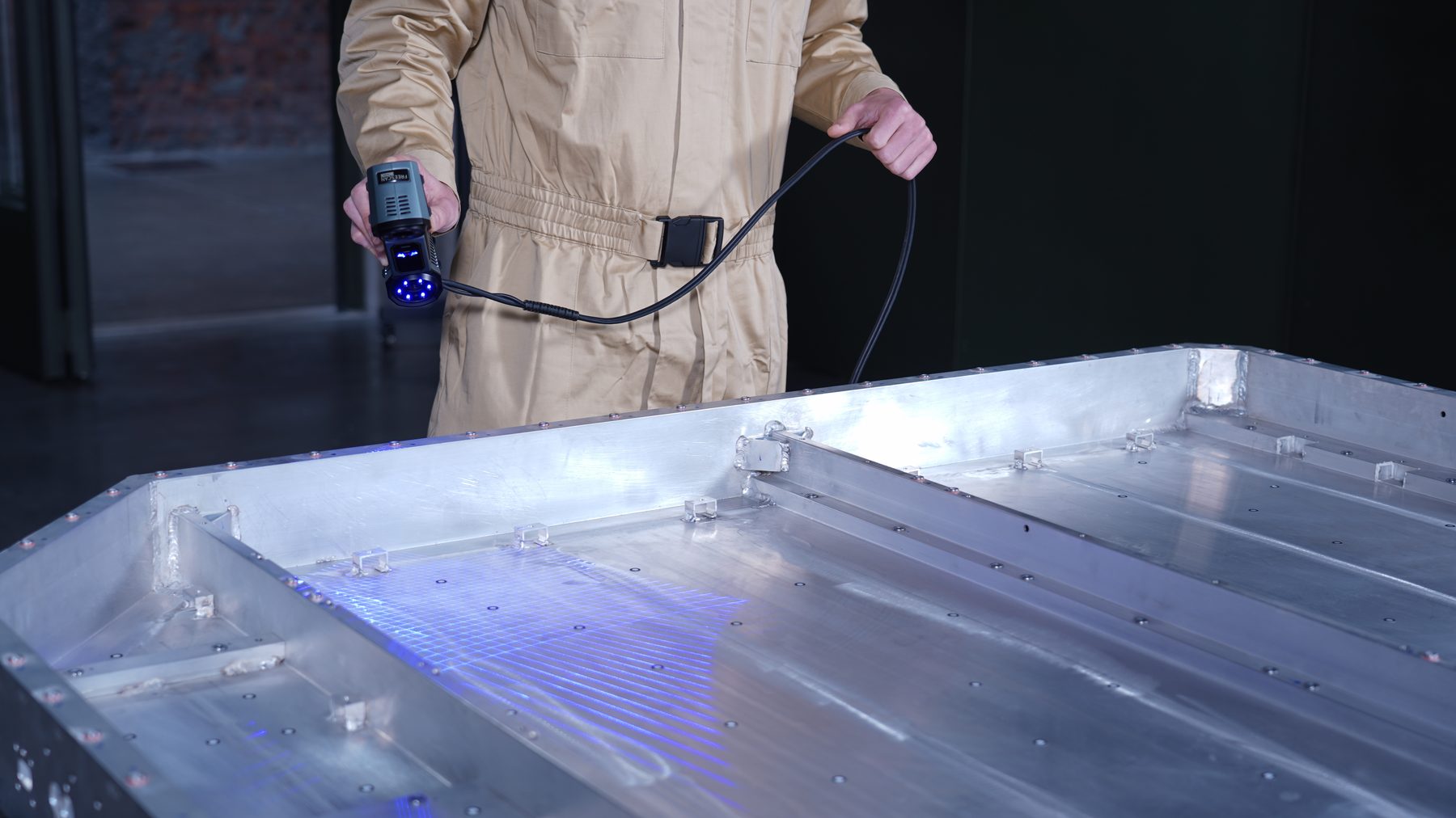 FreeScan Combo Series operator scanning large aluminum panel with 26 parallel blue laser lines — 1,860,000 points per second high-speed area capture